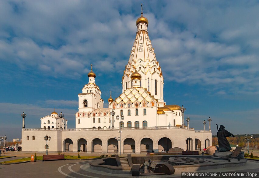 Белый храм с золотой отделкой в лучах закатного солнца