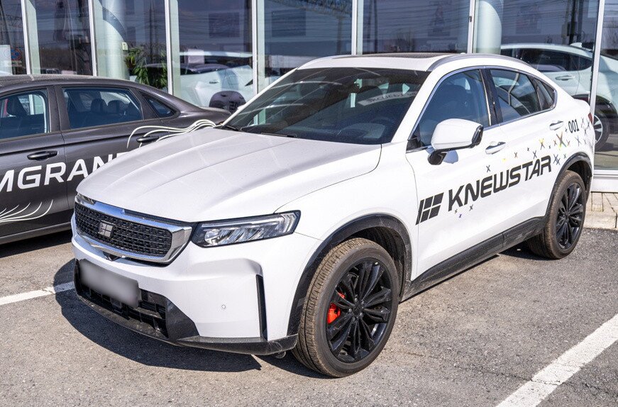 Белый автомобиль Knewstar рядом с автосалоном официального дилера