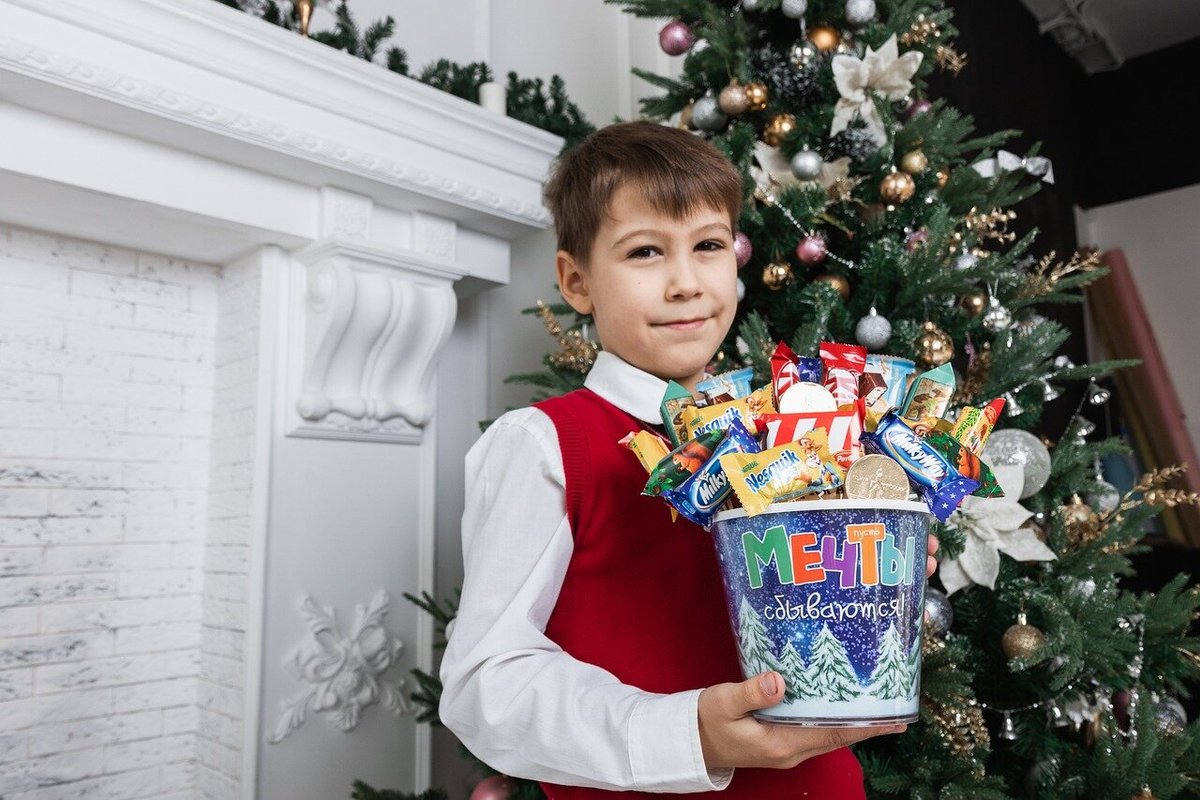 Мальчик с новогодним подарком в руках