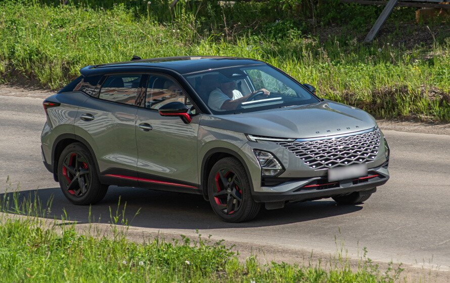 Автомобиль omoda c5 кроссовер серого цвета двигается по дороге