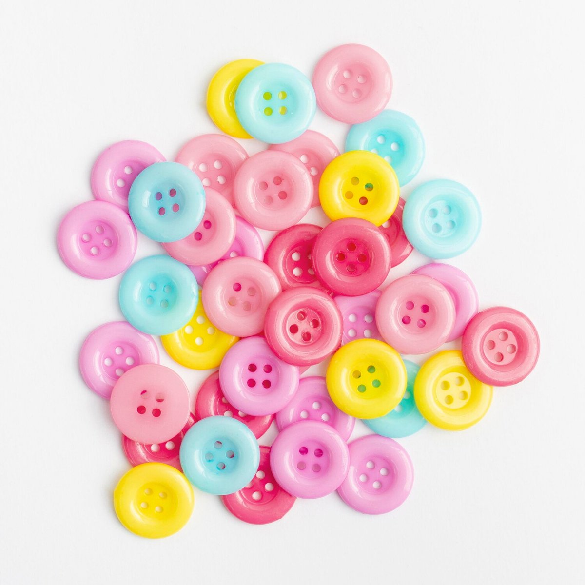Россыпь цветных пуговиц на белом фоне