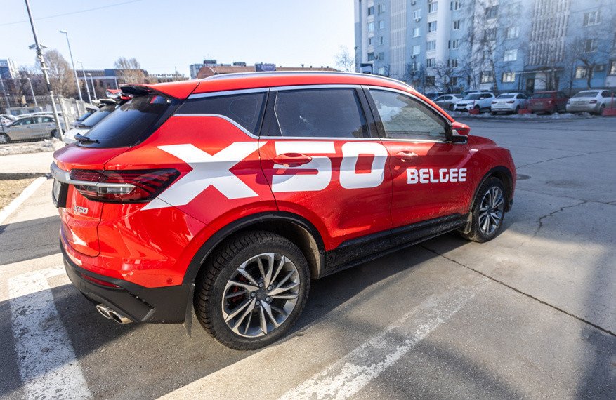 Новый автомобиль BelGee X50 припаркован на улице во дворе автосалона