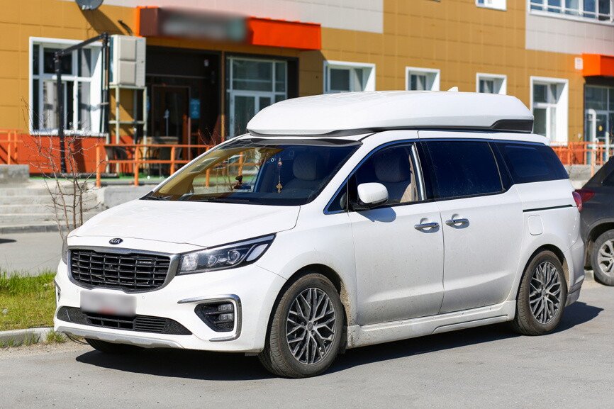 Белый Kia Carnival на улице