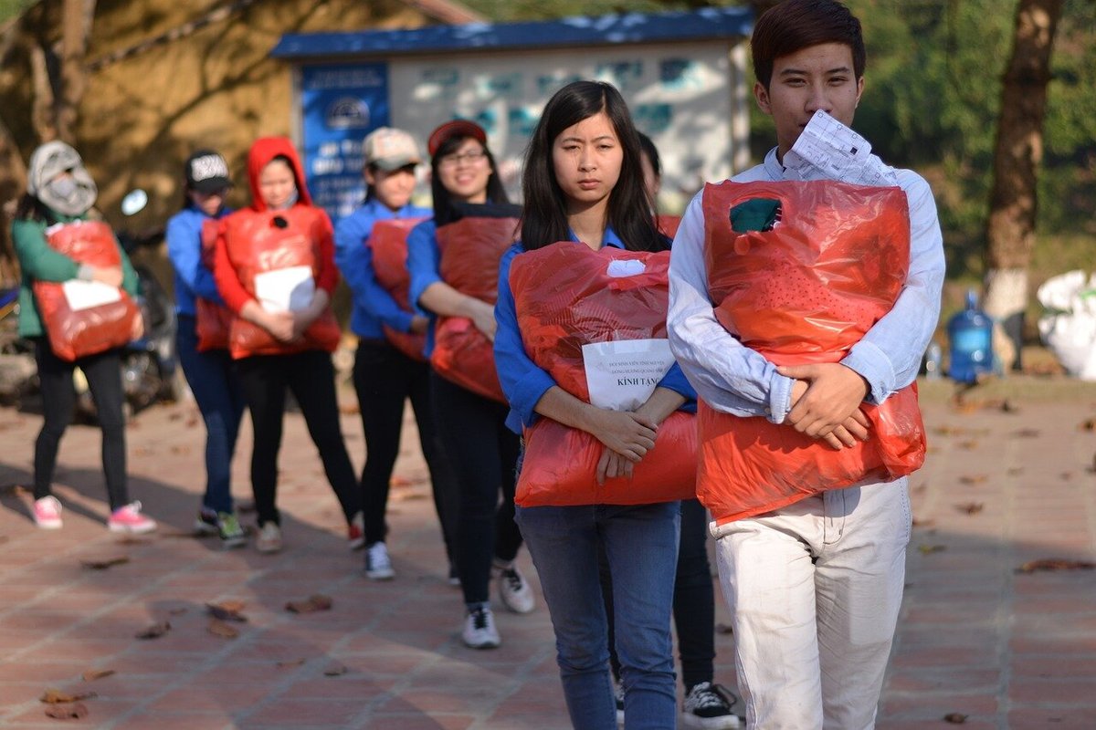 Волонтёры, несущие пакеты с вещами